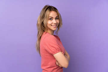 Obraz premium Teenager Russian girl isolated on purple background with arms crossed and looking forward