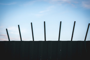 High fence of corrugated board with iron pins to protect the territory.