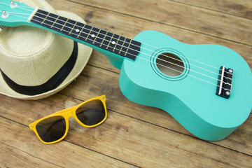 The green ukulele on wooden table background