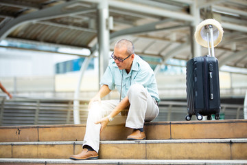 unhappy senior man suffering from knee ache. Travel and tourism concept.health problem and people concept.