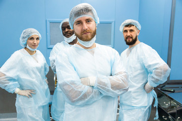 Portrait of a team of doctors in uniform and medical masks after completion of a surgical operation