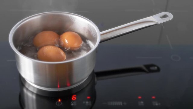 Boiling Eggs.  Eggs being boiled in saucepan on an induction hob.