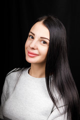 Portrait of serious beautiful female with black hair, has minimal makeup, looks calmly at camera,...
