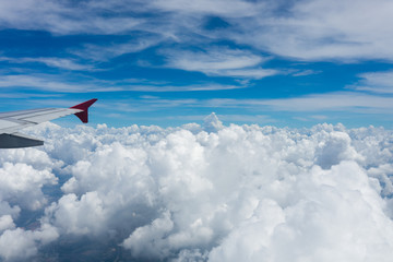 Fototapeta premium Photo from the window of an airplane. View from above on clouds and the earth. High. Sunny and cloudy day. Photo with telephone. View of the sky.