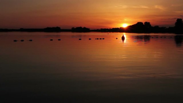 Orange sky in sunset over the lake. Scenic view of sunny rays is on the orange sky in sunset, time over lake. Photo - JPEG video codec