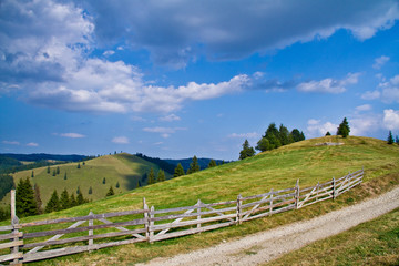 Fototapeta na wymiar rural landscape with wooden fence and blue sky