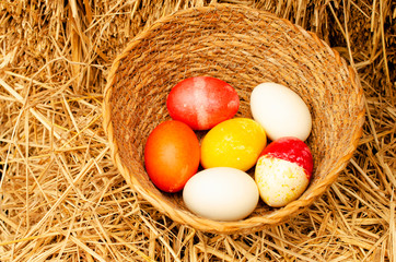 Easter eggs in the basket on straw backgrounds