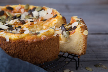 Cheesecake Tart With Pears, Pumpkin Seeds and Almond Petals On Wooden Table with Caramel. Fall Baking Concept.