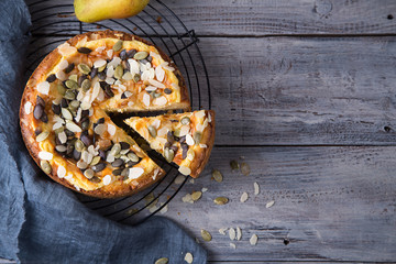 Pears and cheese pie with bowl of caramel, old spoon and fork. Top view. Copy space flat lay