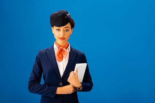 Smiling African American Flight Attendant Holding Digital Tablet Isolated On Blue