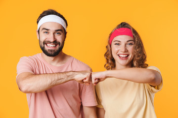 Portrait of athletic couple smiling and bumping their fists together