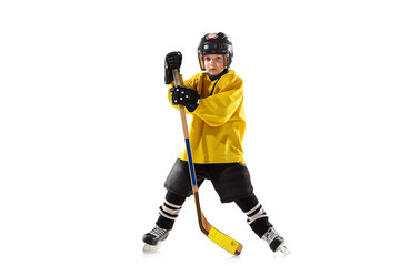 Fototapeta na wymiar Little hockey player with the stick on ice court and white studio background. Sportsboy wearing equipment and helmet practicing, training. Concept of sport, healthy lifestyle, motion, movement, action