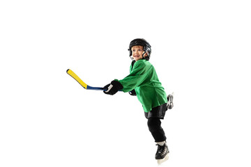 Little hockey player with the stick on ice court, white studio background. Sportsboy wearing equipment and helmet, practicing, training. Concept of sport, healthy lifestyle, motion, movement, action.