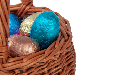 chocolate easter eggs in wooden basket isolated on the white