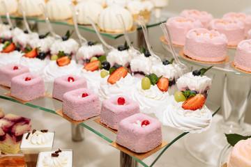 Sweet dessert table or candy bar. Table with different sweets for party. Holiday buffet with cupcakes and other desserts. Macaron, cupcakes, marshmallow close up