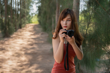 Portrait of a photographer  with the camera outdoor. Asian woman  holding digital camera in her...