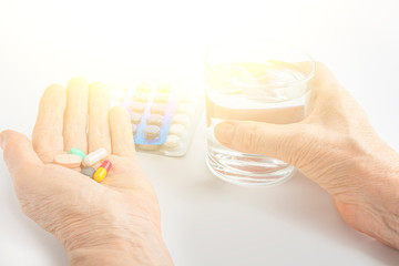 Female hand hold handful of different pills. Healthcare and medical for elder. Medicines for the treatment of diseases of old senior people. Menopause or hormonal drug for woman. Copy space for text
