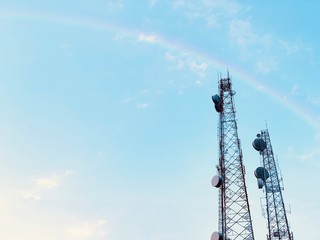 Obraz premium antenna on blue sky with rainbow.