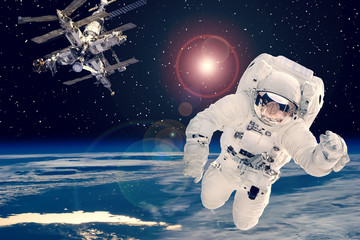 Obraz na płótnie Canvas Astronaut and space station against earth. The elements of this image furnished by NASA.