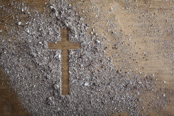 Christian cross symbol made of ash on a wooden background - obrazy, fototapety, plakaty