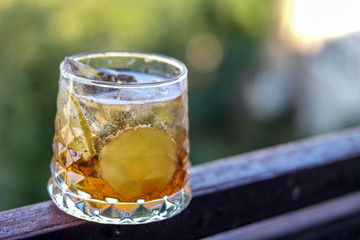 Cocktail glass with ginger and lime on natural background
