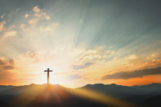 Good Friday concept: cross with sunset in the sky background