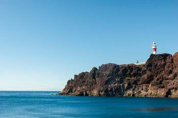 Fototapeta na wymiar Lighthouse on Teno cape. The westernmost point of the island of Tenerife. View of the rock with a lighthouse.