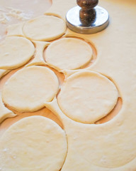 raw dough cut into circles for the preparation of pies. the process of making stuffed pies