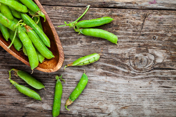 Green peas in a wooden bowl.