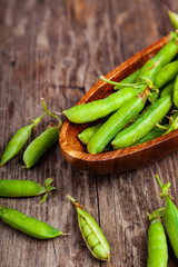 Green peas in a wooden bowl.