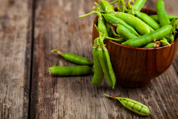 Green peas in a wooden bowl.