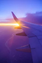 Wall murals Dark blue Beautiful sunset, sky on the top view, airplane flying view from inside window and cloud, sun down background aircraft of Traveling.