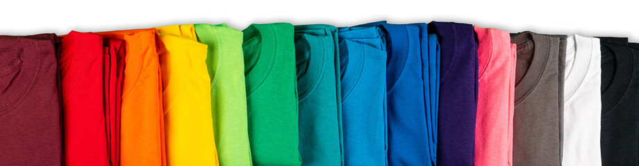 wide panorama row of many fresh new fabric cotton t-shirts in colorful rainbow colors isolated. Pile of various colored shirts white background - obrazy, fototapety, plakaty