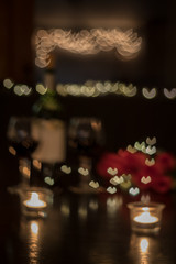 Abstract defocused background of red wine and roses on dark table for romantic dinner date night heart bokeh