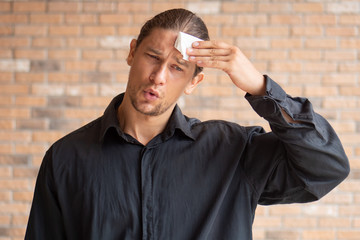 tired exhausted thirsty sweating man suffering from hot weather, heatstroke, high temperature;...