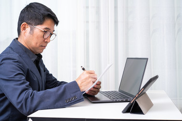 Senior Asian businessman working on laptop computer