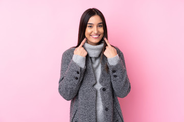 Young brunette woman over isolated pink background smiling with a happy and pleasant expression