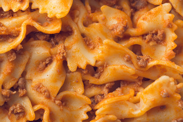 Farfalle pasta with tomato bolognese sauce macro texture still