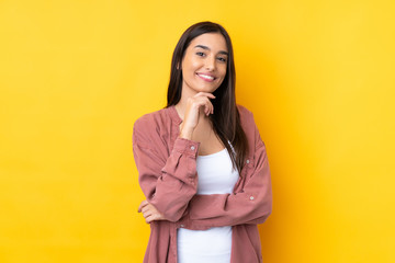 Young brunette woman over isolated yellow background smiling