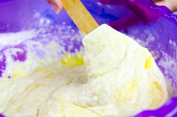 Close-up hand of a young girl whips the dough with an egg whisk in the kitchen - 323956221