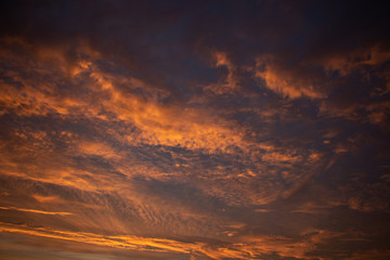 Beautiful colored cloudy skies in the colors blue, magenta, orange, purple, pink and yellow at sunrise in the Netherlands during the winter