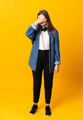 Student ukrainian teenager girl over isolated yellow background covering eyes by hands