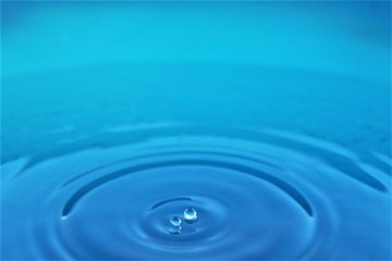 Splashing water drop on blue water background photo