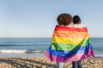 couple of gay girls wrapped in the rainbow flag - Powered by Adobe