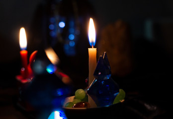 Fortune-telling attributes and two candles burn in a dark room. The ritual of mysticism....