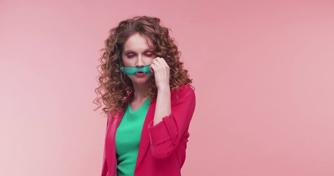 Glamorous Young female Model working at Studio, posing and looking Stylish. Pretty Woman Wearing Colorful trendy clothes. Having fashionable outfit. Looking stylish, touching her Eyeglasses.