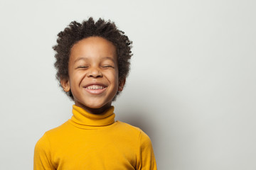 Cute schoolboy black kid boy laughing on white background
