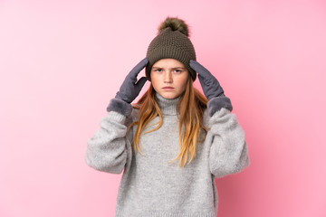 Ukrainian teenager girl with winter hat over isolated pink background unhappy and frustrated with something. Negative facial expression