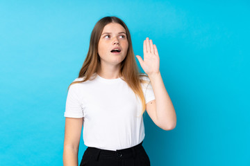 Ukrainian teenager girl over isolated blue background shouting with mouth wide open