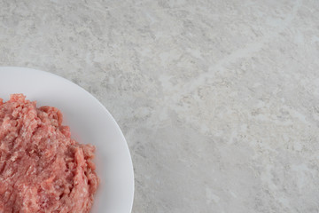 natural fresh minced meat on a white plate.